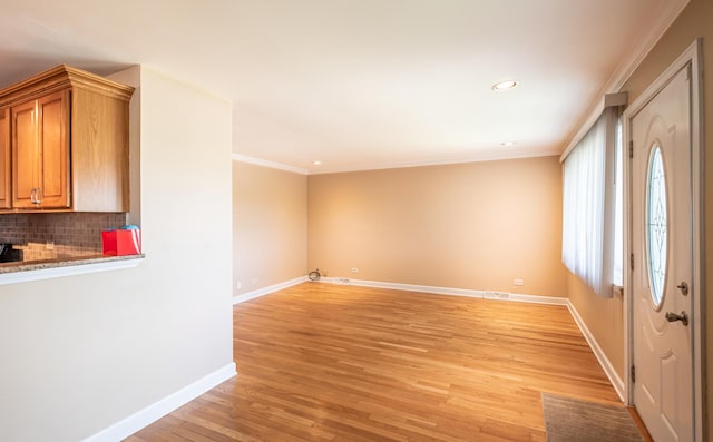 interior space with ornamental molding and light hardwood / wood-style floors