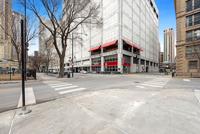 view of street featuring traffic signs, street lighting, curbs, and sidewalks