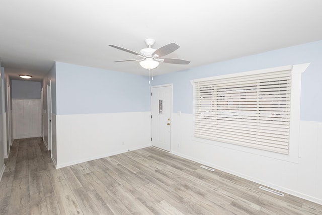 empty room with ceiling fan and light hardwood / wood-style floors