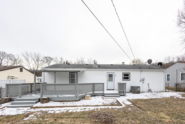 snow covered back of property featuring cooling unit and a wooden deck