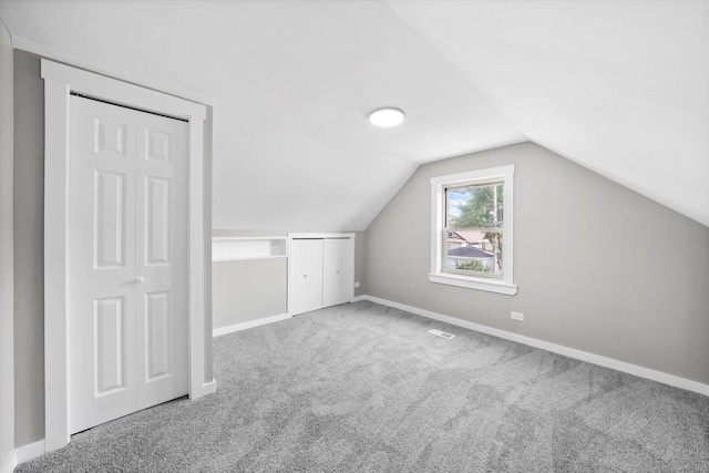 bonus room with vaulted ceiling and carpet flooring