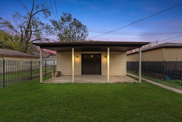 back house at dusk featuring a garage, an outdoor structure, and a lawn