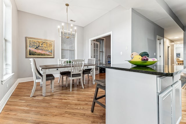 dining space featuring an inviting chandelier and light hardwood / wood-style flooring