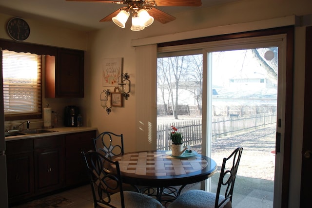 dining area with ceiling fan, plenty of natural light, tile patterned flooring, and sink