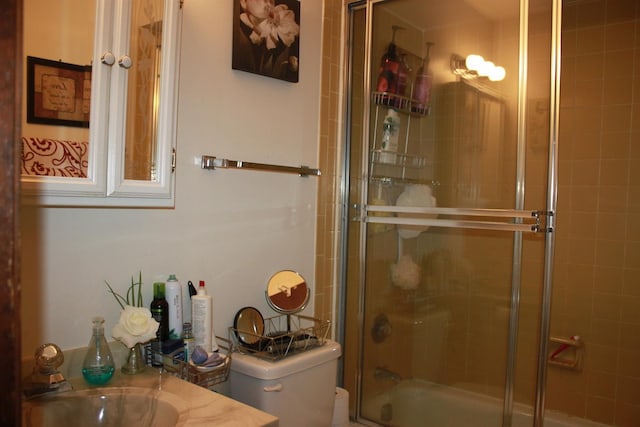 full bathroom featuring enclosed tub / shower combo, vanity, and toilet