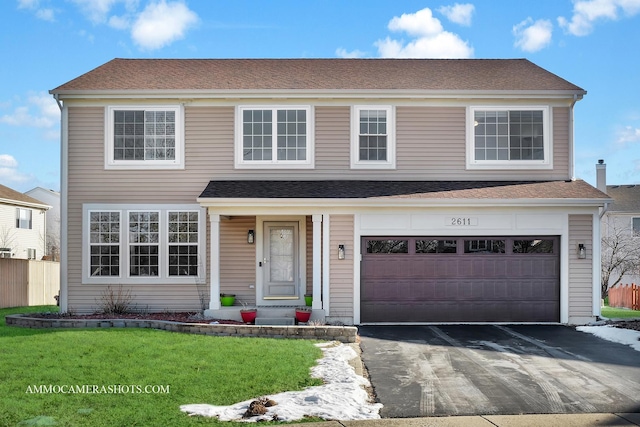 view of front of property featuring a garage and a front lawn