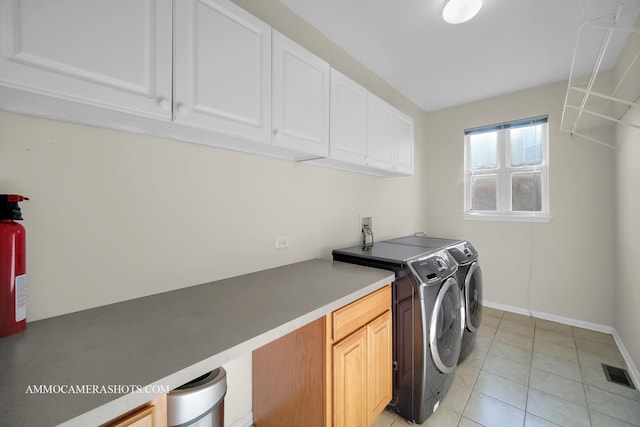 washroom with cabinets, light tile patterned floors, and washing machine and clothes dryer