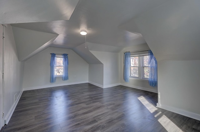 bonus room featuring vaulted ceiling, a healthy amount of sunlight, and dark wood-type flooring