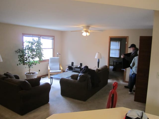 carpeted living room featuring ceiling fan