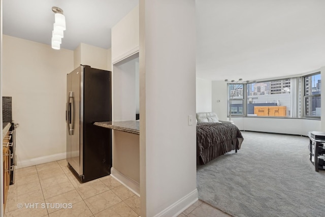 bedroom featuring light colored carpet and stainless steel fridge