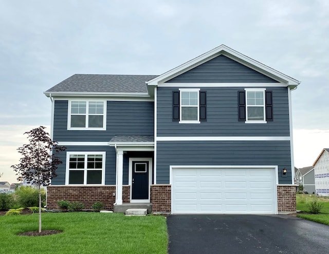 view of front of property featuring a garage and a front lawn