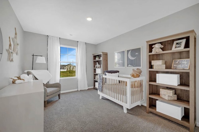 bedroom featuring a nursery area and carpet floors