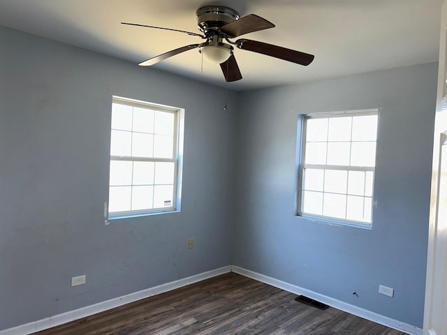 empty room with dark hardwood / wood-style flooring, plenty of natural light, and ceiling fan