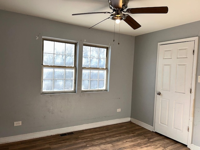 empty room featuring dark hardwood / wood-style flooring and ceiling fan