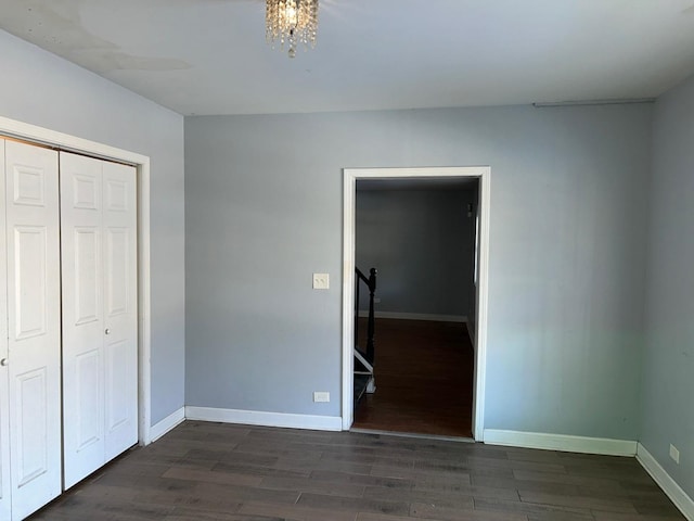 unfurnished bedroom with dark wood-type flooring and a closet