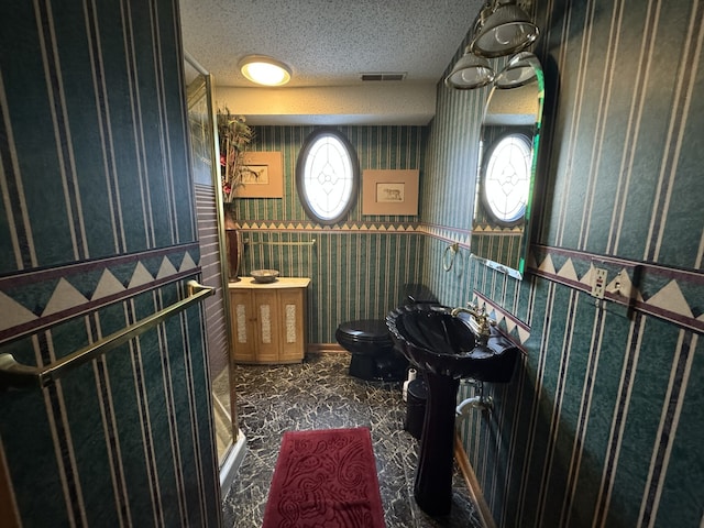 bathroom with toilet and a textured ceiling