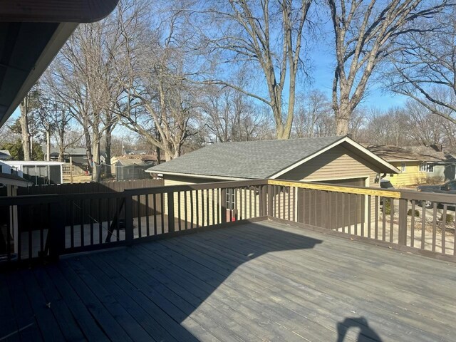 view of property exterior featuring a garage, an outdoor structure, and a deck