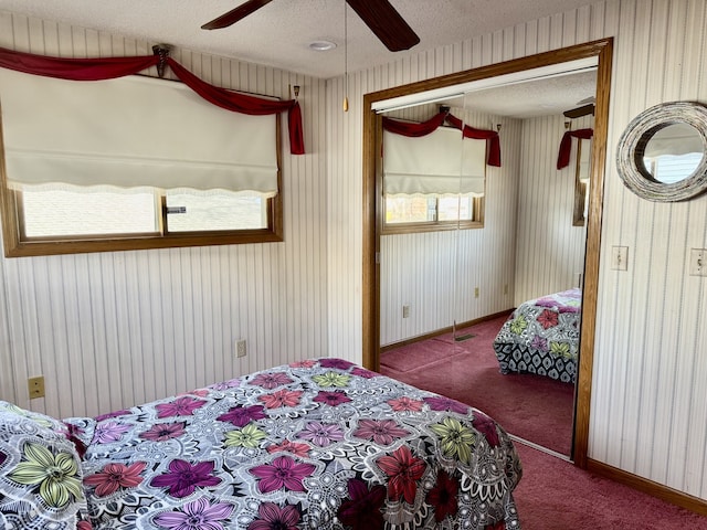 bedroom with ceiling fan, carpet, and a textured ceiling