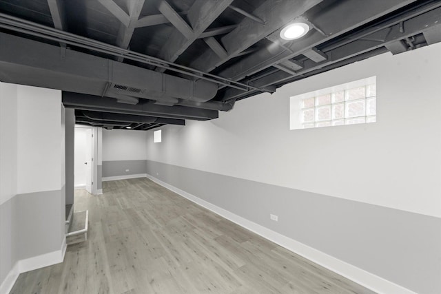 basement with light hardwood / wood-style flooring