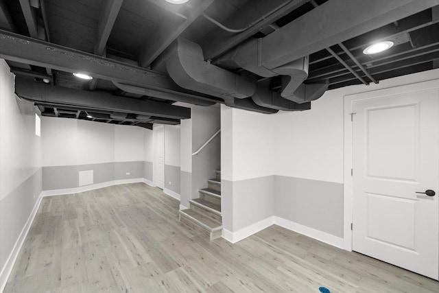 basement with light hardwood / wood-style flooring