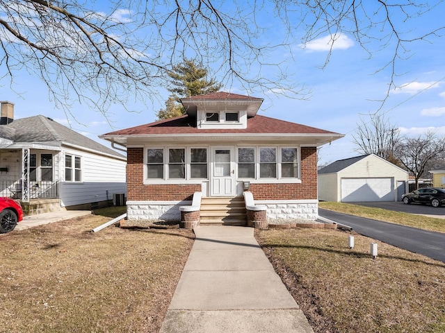 bungalow featuring a garage, brick siding, central AC unit, and an outdoor structure