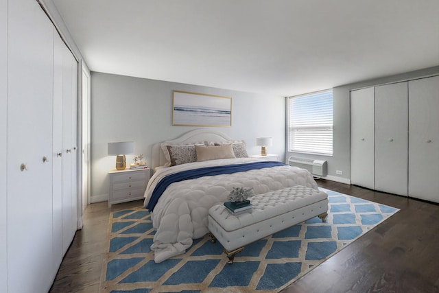 bedroom featuring an AC wall unit and dark hardwood / wood-style floors