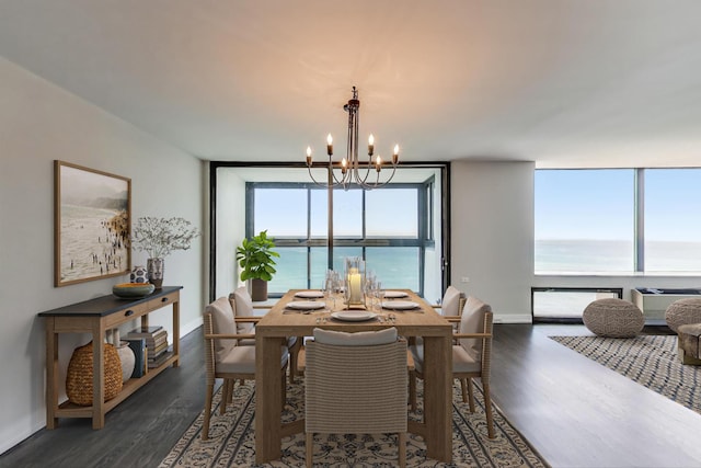 dining space with a water view, floor to ceiling windows, dark wood-type flooring, and an inviting chandelier