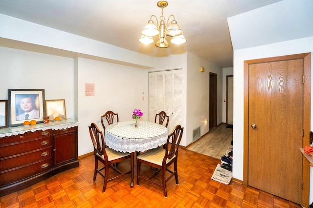 dining room featuring parquet floors and a notable chandelier