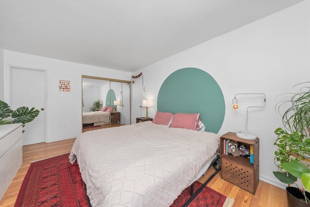 bedroom with light hardwood / wood-style flooring and a closet