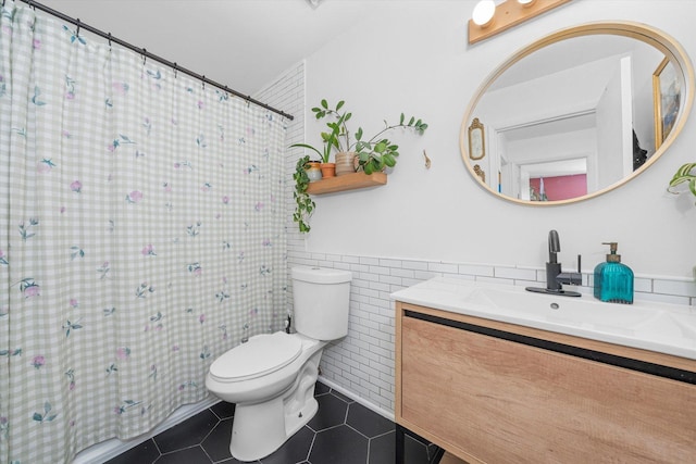 bathroom featuring toilet, a shower with curtain, tile walls, vanity, and tile patterned flooring