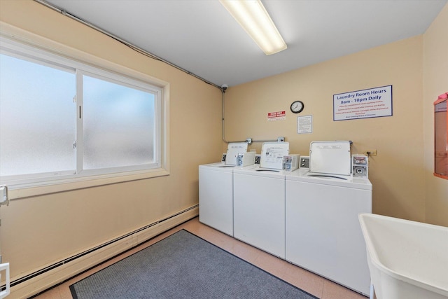 clothes washing area with light tile patterned flooring, independent washer and dryer, and baseboard heating