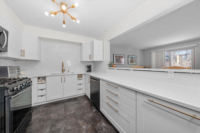 kitchen featuring sink, tasteful backsplash, an inviting chandelier, stainless steel appliances, and white cabinets