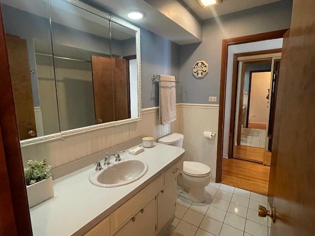 bathroom featuring a wainscoted wall, vanity, toilet, and tile patterned floors