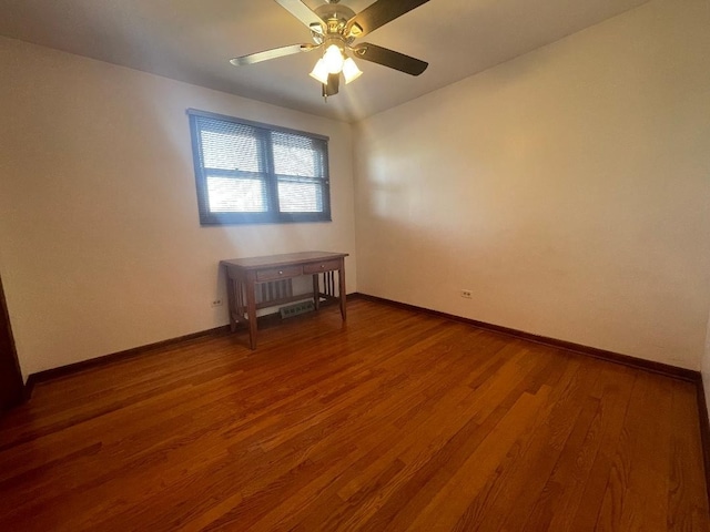 empty room featuring ceiling fan, wood finished floors, and baseboards