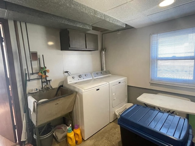 clothes washing area featuring laundry area, washing machine and dryer, and a sink