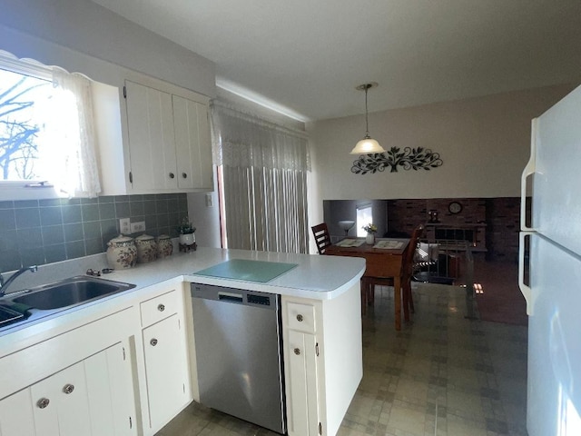 kitchen featuring light countertops, hanging light fixtures, white cabinetry, dishwasher, and a peninsula