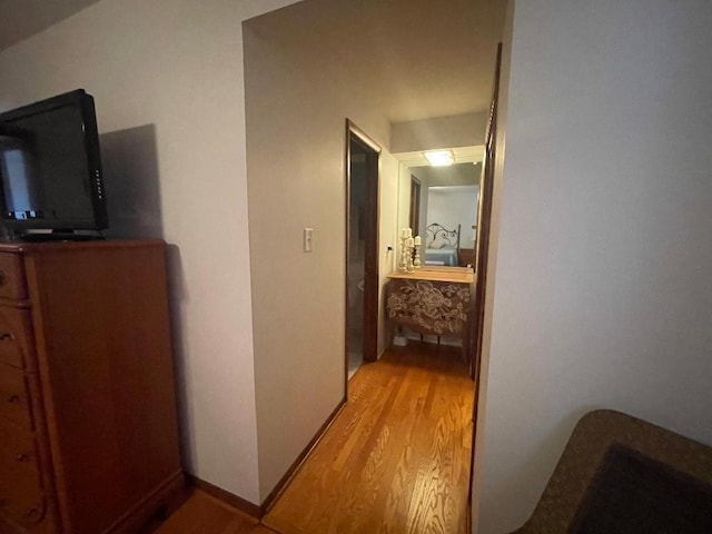 hall featuring light wood-type flooring and baseboards