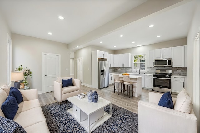 living room featuring sink and light hardwood / wood-style flooring