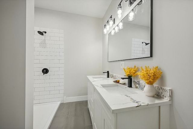 bathroom featuring vanity, hardwood / wood-style floors, and tiled shower