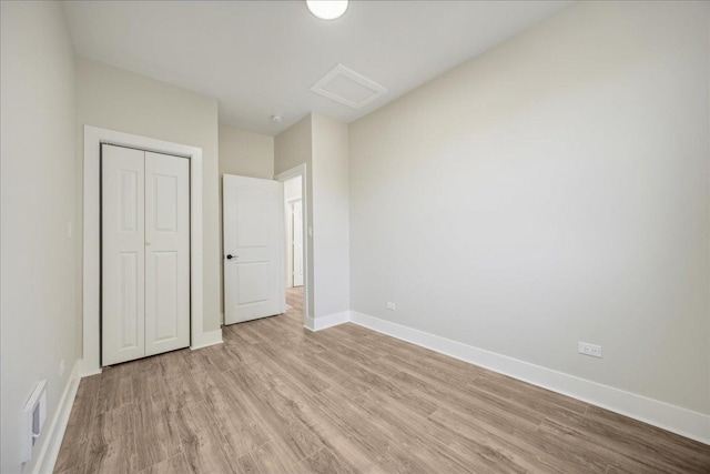 unfurnished bedroom with a closet and light wood-type flooring