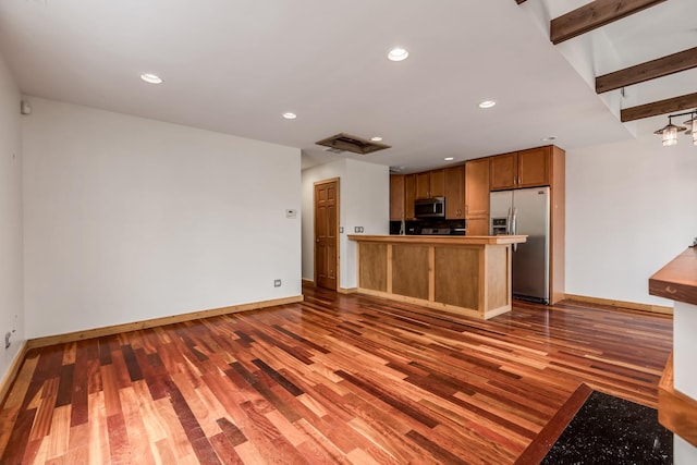 kitchen with dark hardwood / wood-style flooring, beam ceiling, stainless steel appliances, and kitchen peninsula