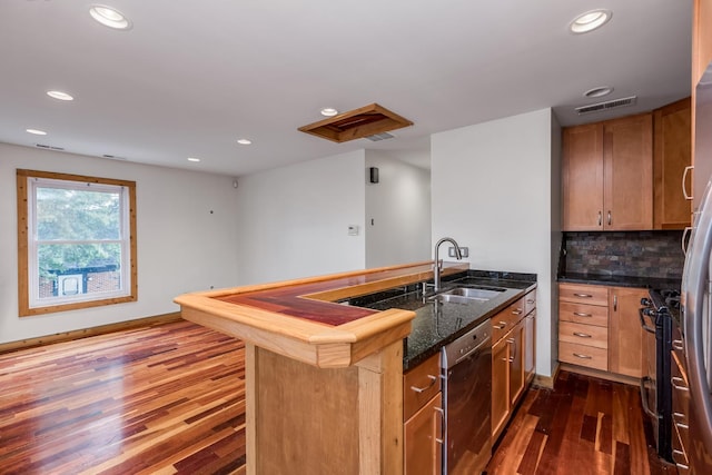 kitchen featuring dark wood-type flooring, sink, dishwashing machine, kitchen peninsula, and backsplash