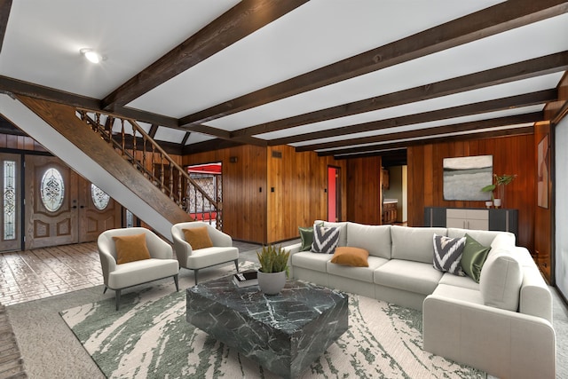 living room featuring beam ceiling and wooden walls