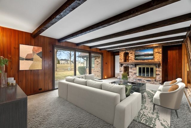 carpeted living room with a brick fireplace, beam ceiling, and wood walls