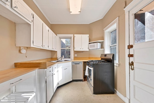 kitchen featuring ornamental molding, appliances with stainless steel finishes, sink, and white cabinets