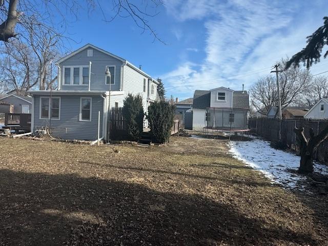 back of property featuring a trampoline