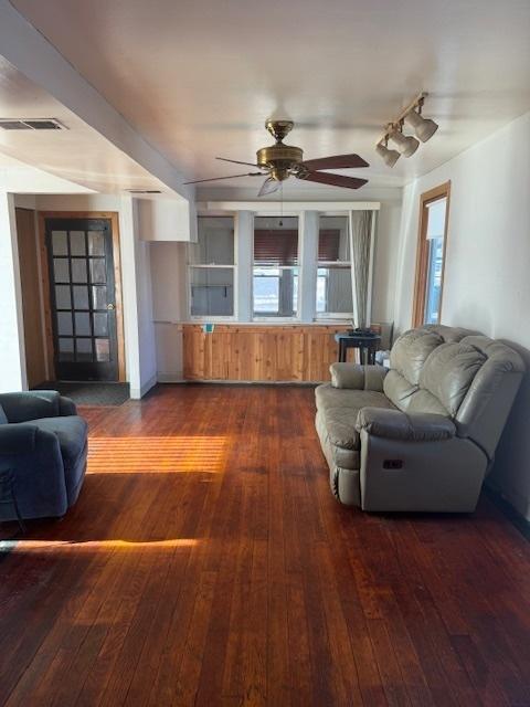 living room featuring dark wood-type flooring and ceiling fan