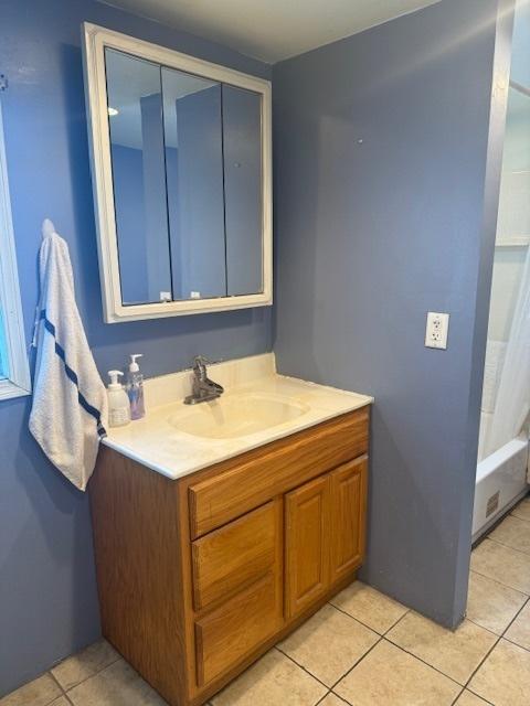 bathroom with shower / bath combination with curtain, vanity, and tile patterned flooring