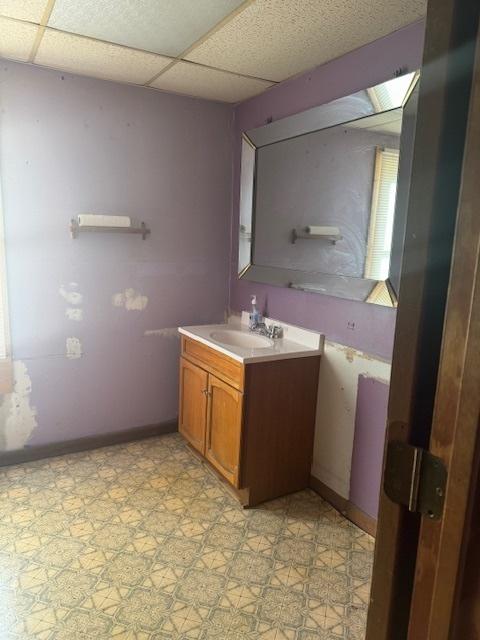 bathroom featuring a paneled ceiling and vanity