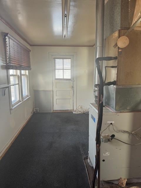 basement featuring ornamental molding and heating unit